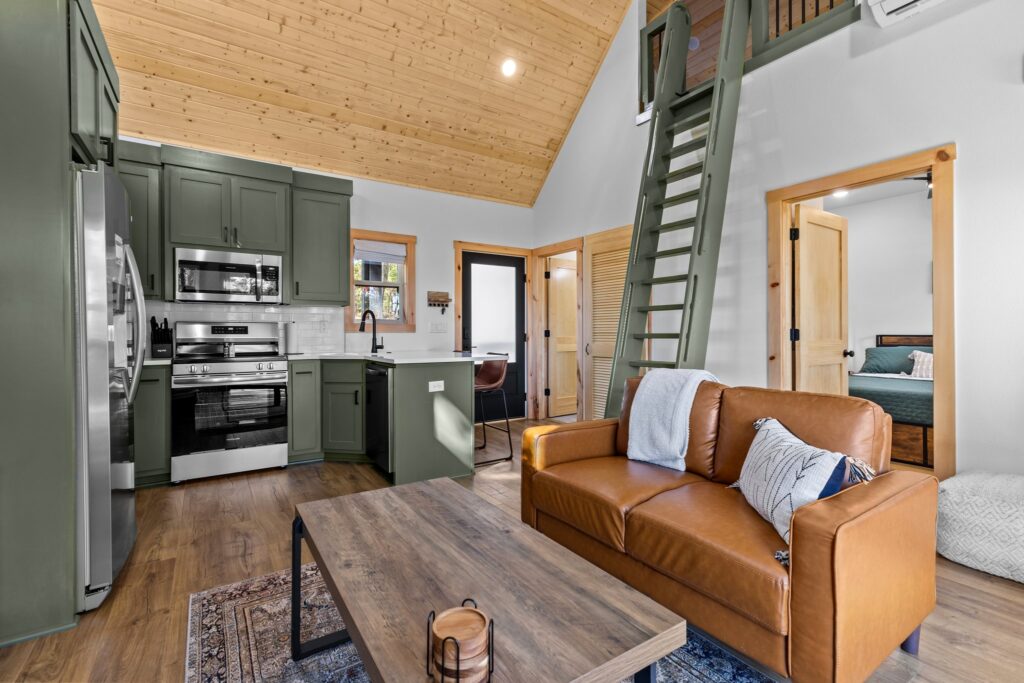 Open living room and kitchen beneath the vaulted wood ceiling